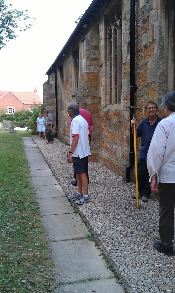 Volunteers laying new gravel outside the church